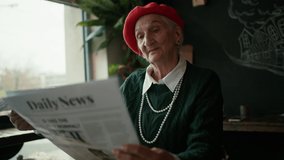 Elegant senior woman with silver hair and pearls reading newspaper in cafe. - Powered by Shutterstock - Get 15% off with code: PIKWIZARD15