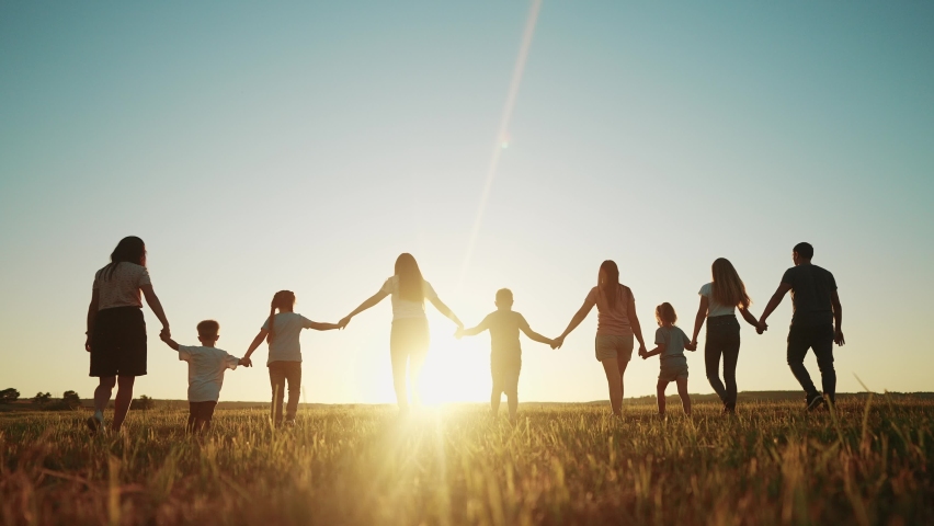 community large family in the park. a large group of people holding hands walking silhouette on nature sunset in the park. big family kid dream concept. people in the park. large sunlight family Royalty-Free Stock Footage #1095103473