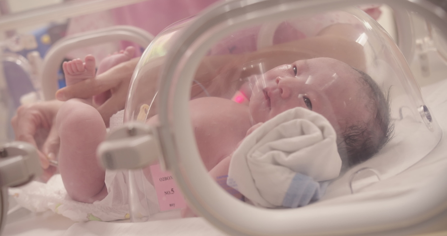 Closeup lovely little newborn baby infant lying in incubators for newborns, Newborn baby having the the breathing problem after birth, newborn in NICU, Neonatal intensive care unit
 Royalty-Free Stock Footage #1095107473