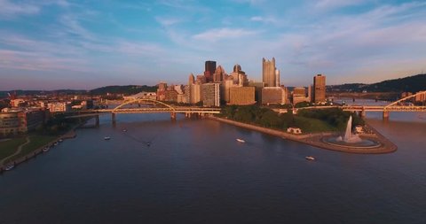 An aerial tracking shot of Pittsburgh, Pennsylvania and Point State Park at sunset.  (Pittsburgh PA, July 2015)