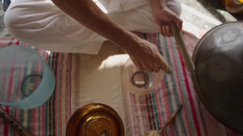 Hands of unrecognizable man playing tibetan bowl in sound healing session. Ancestral Asian medicine  Video Stok