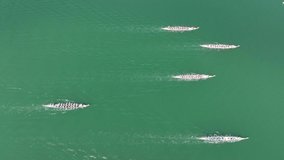 Aerial video of a group of dragon boat racers as they race along the water in 4K video. 