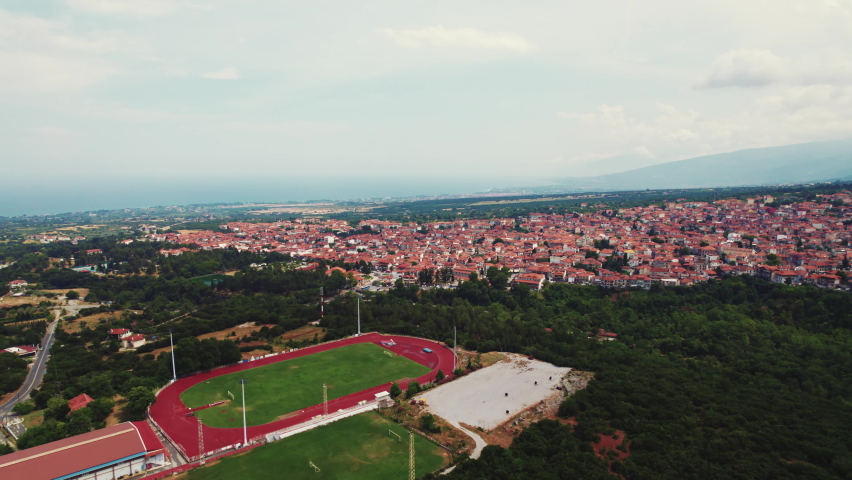 Professional stadium in the city of Thessaloniki in Greece. Aerial drone perspective. Sports concept. Cloudy sky. High quality 4k footage
