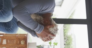 Vertical video of senior african american man touching head at home. healthy, active retirement at home.
