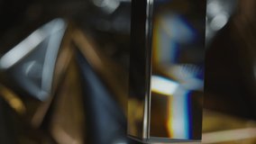 Selective focus close up shot of glass prism hanging and dispersing light on metallic background - Powered by Shutterstock - Get 15% off with code: PIKWIZARD15