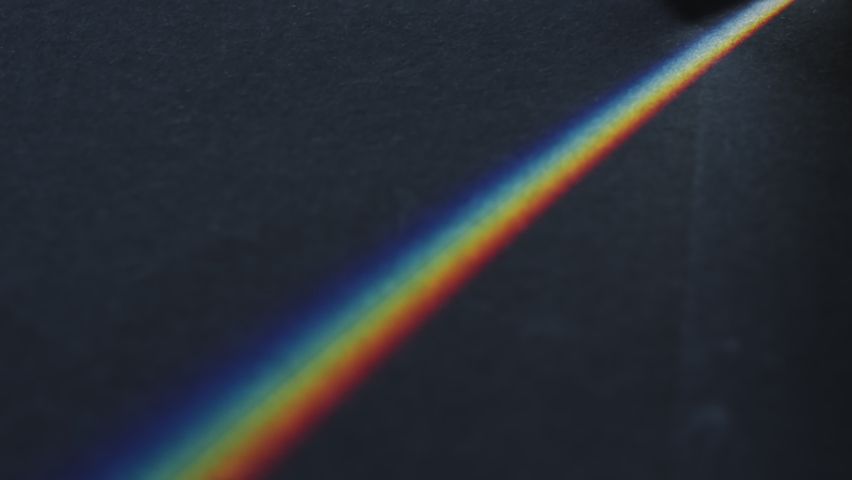 Close up tilt up shot of glass prism being moved and dispersing light into spectrum of rainbow colors Royalty-Free Stock Footage #1095125573