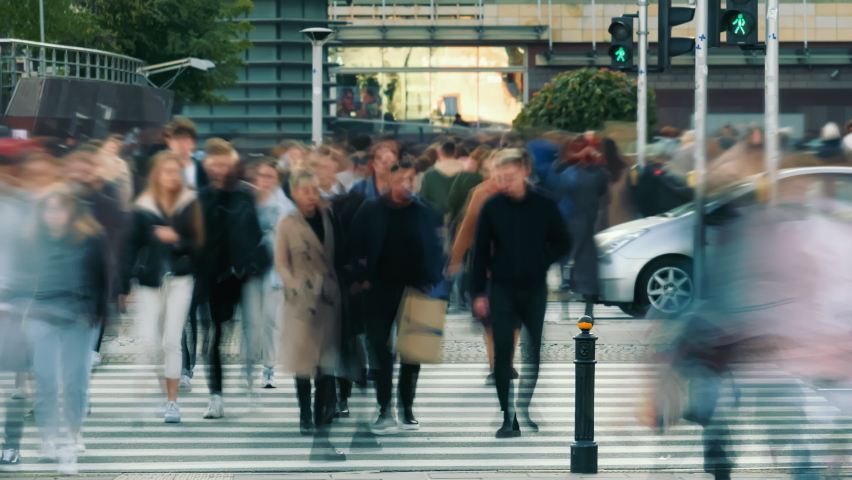 Time-lapse unrecognizable people crowd crossing city street, busy crossroad, pedestrians crossing crosswalk intersection, car traffic. Timelapse rush hour crowded people walk, daylight, fast motion