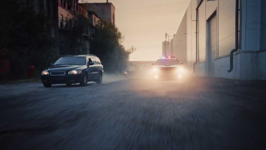 Traffic Patrol Car in Pursuit of Criminal Vehicle. Police Officers in Squad Car Chasing Suspect on Industrial Road, Sirens Blazing, High Speed. Stylish Cinematic Dolly Zoom Shot of Action Scene | Shutterstock HD Video #1095135025