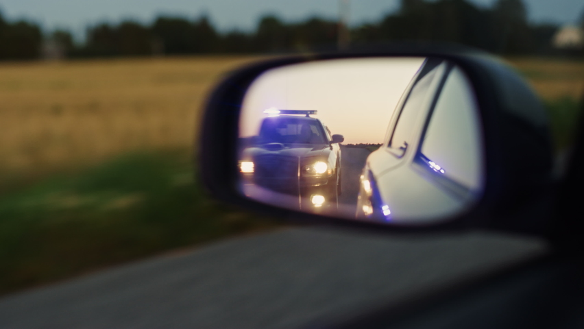 Stylish Side Mirror Car Chase Shot: Highway Traffic Patrol Vehicle Pull over Suspect. Professional Female Police Officer Approaches Vehicle, Asks Driver License and Registration. Cinematic Shot Royalty-Free Stock Footage #1095135055