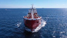 Aerial drone tracking video of massive crude oil tanker stern cruising near Mediterranean logistics port