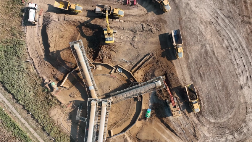 Tipper Trucks Receiving Earth from a Digger and Conveyor Royalty-Free Stock Footage #1095141649