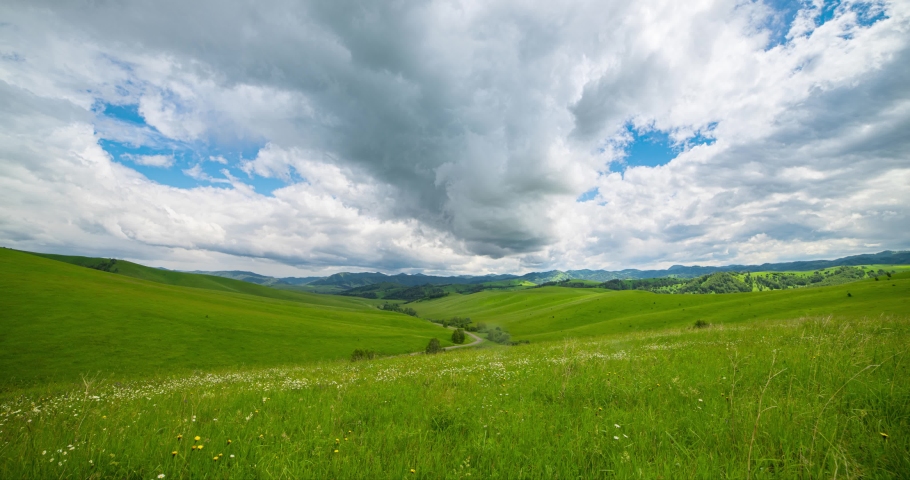 Mountain meadow time-lapse at the summer or autumn time. Wild nature and rural field. Fast clouds movement, green grass and sun rays. Motorised panorama Royalty-Free Stock Footage #1095141777