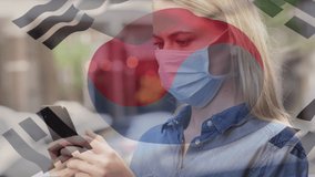 Animation of flag of south korea waving over caucasian woman wearing face mask in city street. global health precautions during covid 19 pandemic concept digitally generated video.