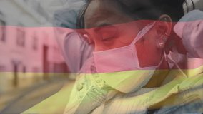 Animation of flag of germany waving over african american woman wearing face mask in city street. global health precautions during covid 19 pandemic concept digitally generated video.