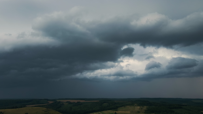 Landscape of dark clouds forming on stormy sky during thunderstorm over rural area