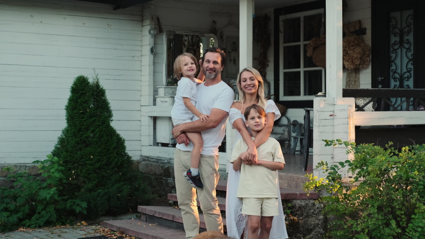Happy caucasian family are standing near the house. Royalty-Free Stock Footage #1095147357