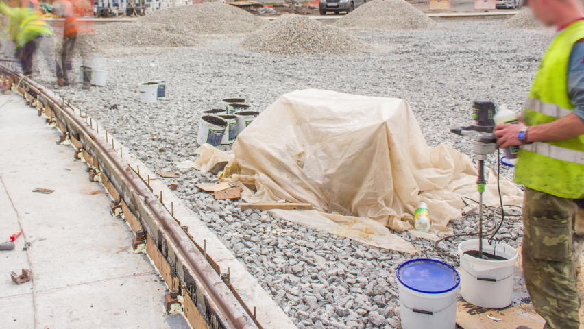 Workers install new tram rails on concrete plates during a reconstruction of the route timelapse. Filling by liquid resin for reduction of vibration and noice. Modernizations of tram tracks