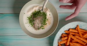 Flat lay food cooking video: chef mixes white sauce with spices, 4k