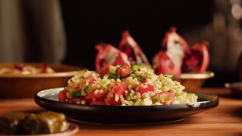 Tabbouleh Vegetable Salad close-up, middle eastern national traditional food. Muslim family dinner, Ramadan, iftar. Arabian cuisine, hummus and dolma dish on table. Royalty-Free Stock Footage #1095149811