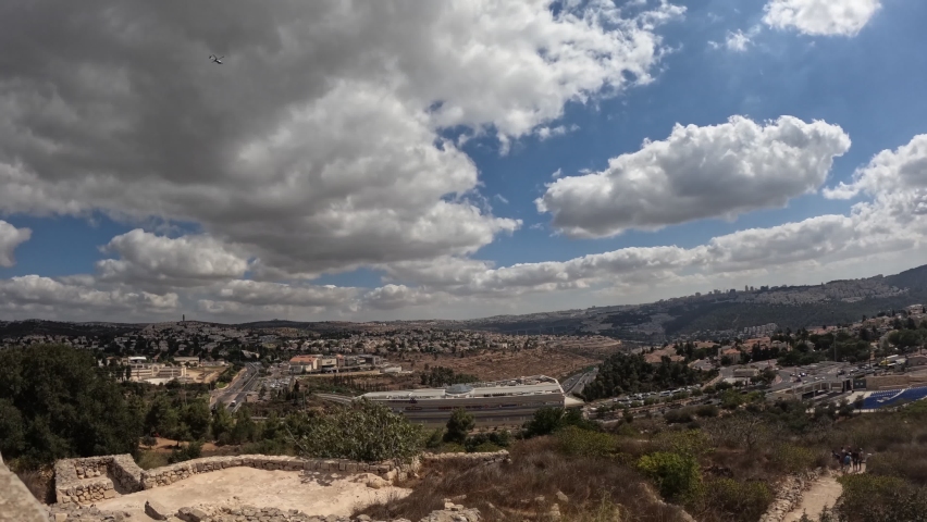 Panorama of the Jerusalem mountains, residential buildings and neighborhoods. Against a cloudy sky. View from road number 1.