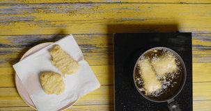 Flat lay food video: fish fillet is fried in the hot boiling oil, deep fry 4k