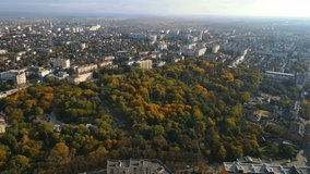 Drone aerial video in central park of city. Beautiful autumn panorama. Street traffic life and buildings.
