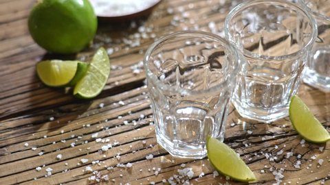 Стоковое видео: Pouring several glasses of Mexican Mezcal or Tequila shots.
Classic Tequila small glasses being served.