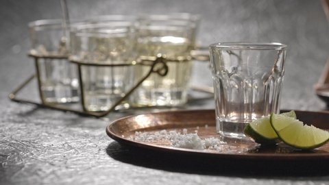 Стоковое видео: Pouring several glasses of Mexican Mezcal or Tequila shots.
Elegant glasses and tray to serve traditional drinks distilled from Cactus.
