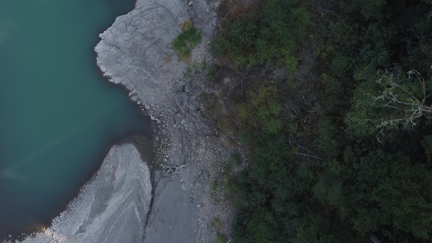 Aerial, birds-eye, footage of the Cowlitz River and the rocky banks near Riffe Lake located in Lewis County, Washington.
