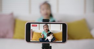 Young r cute influencer fun selfie home video with pet dog live on  reel   stories Asia vlogger small girl blogger alpha kid record blog vlog on phone Dream job side hustle