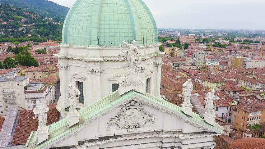 Inscription on video. Brescia, Italy. Cathedral of Santa Maria Assunta. Flight over the city in cloudy weather. Text from small balls, Aerial View, Departure of the camera