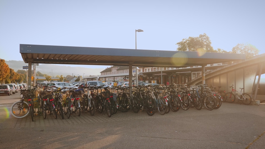 Bicycles stand and parking at railway Station. Bikes parked at parking lot in sunny morning. Lot of city bicycles standing one next to another