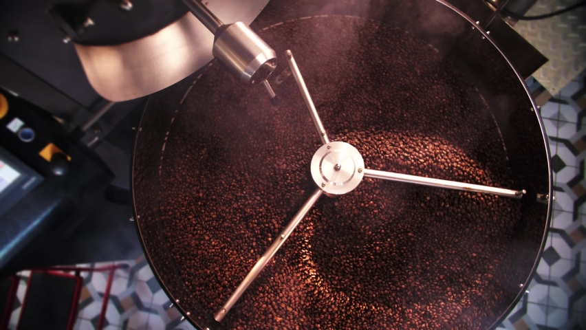 Coffee roaster machine mixing aroma beans.Preparation fresh aroma caffeine on manufacturing warehouse.Top View Make ready coffee in large roaster. High quality 4k footage Royalty-Free Stock Footage #1095199451