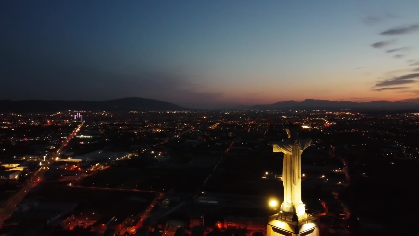 Aerial drone view of Monteagudo Christ castle at night against  sunset and Murcia cityscape in Spain. Replica  of the Christ located on the top of the Concorvado Mountain in Rio de Janeiro dron shot. Royalty-Free Stock Footage #1095210277