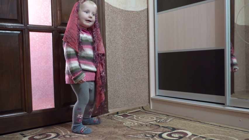 little girl dancing,a girl with a scarf on her head dances in the room