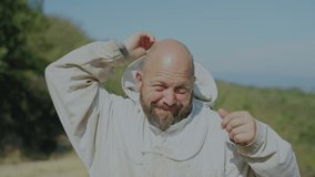 Beekeeper removing his protective helmet outside the apiary - Powered by Shutterstock - Get 15% off with code: PIKWIZARD15