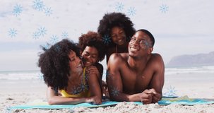 Animation of fir tree frame and snowflakes over happy african americna family on beach. Christmas, tradition, celebration and family time concept digitally generated video.