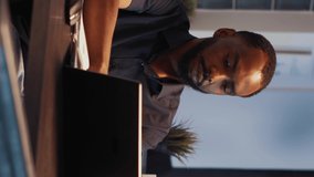 Vertical video: African american employee brainstorming ideas to create report online on company network late at night. Using laptop to plan executive research project and presentation, web app.