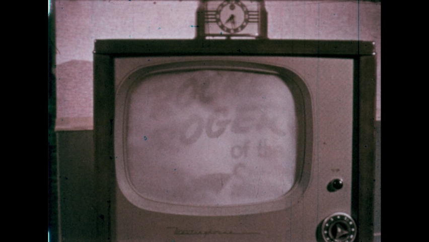 1960s: TV shows Rocket Roger of the Space Force. Boy turns off TV and thinks hard. Fireman at fire station. Emergency bell rings.