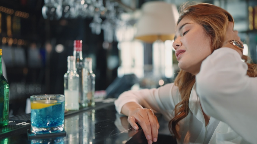 A bored and sad woman drinking cocktail drink sitting at bar counter in restaurant Royalty-Free Stock Footage #1095243489