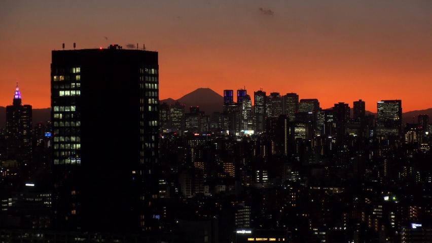 TOKYO, JAPAN : Aerial high angle sunrise CITYSCAPE of TOKYO and MOUNT FUJI. View of buildings around Shinjuku. Japanese urban metropolis and nature concept shot. Long time lapse shot night to morning.