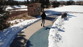 Man Running in Snowy Park • Active Tracking Shot