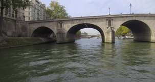 Bateau-mouche sailing on the Seine and passing under the Pont Marie in Paris.