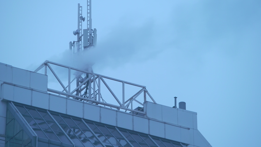 Building rooftop GSM antenna. Repeater antenna. GSM network antenna tower. Mobile communication antenna. Global system mobile communication tower. Cellular tower broadcast transmitter receiver.