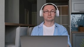 Happy man with headphones on having online video call at work or talking with customer.Or teacher giving lecture online.Work from home concept.Online education