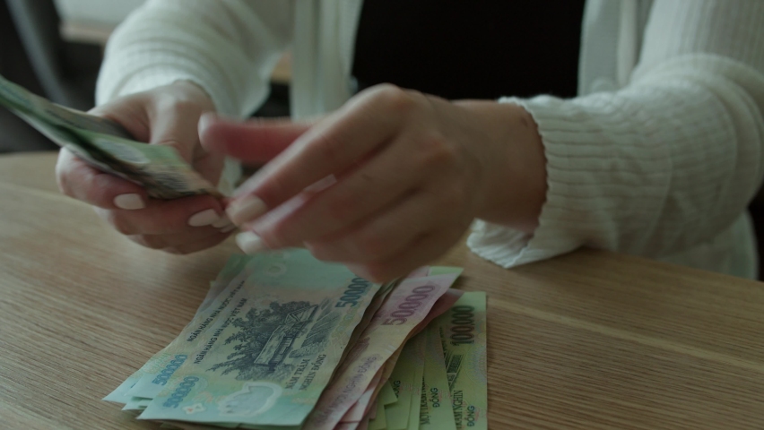Women's hands make a fan of money, the girl counts Vietnamese dongs or cash at home. Concept about investment, success, financial prospects or career growth. Royalty-Free Stock Footage #1095263851