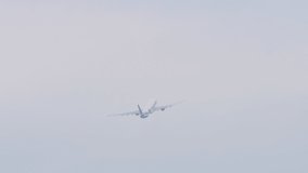 Footage unrecognizable jet plane flies away, gaining altitude, rear view long shot. Tourism and travel concept