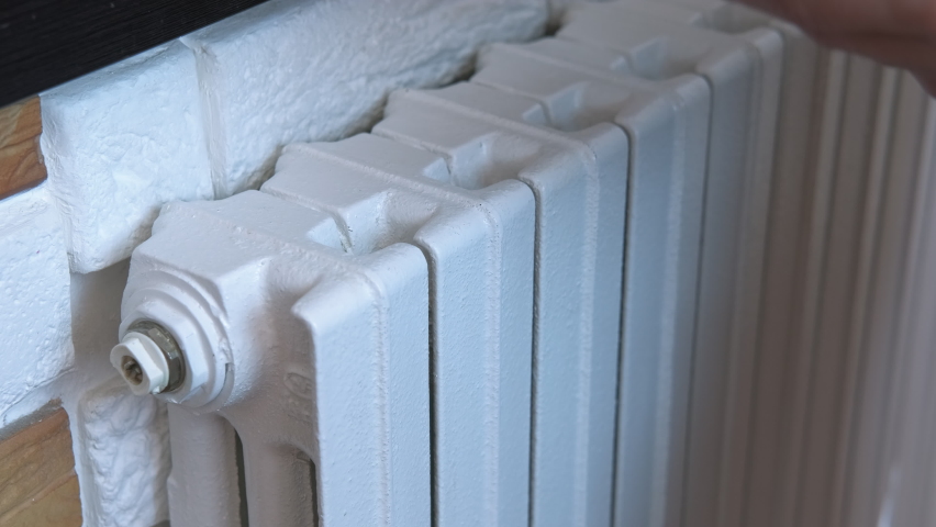 Expensive bills for central heating. A woman puts her money for household and heating on the radiator in the room. A concept of expensive cost of heating during winter crisis time. Royalty-Free Stock Footage #1095267661