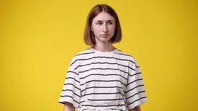 4k video of upset offended woman isolated over yellow background.
