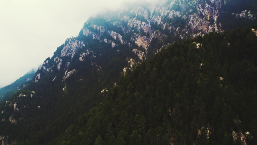 Mount Olympus - mythological home of the Greek gods. Aerial perspective of a part of the hill covered with dark green forest trees. Cloudy sky. High quality 4k footage